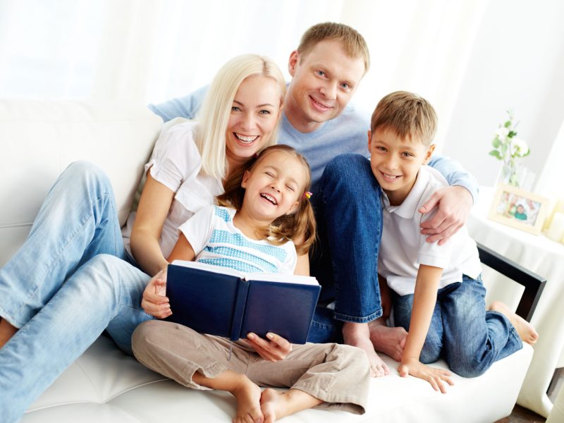 Portrait of happy family with two children looking at camera and laughing